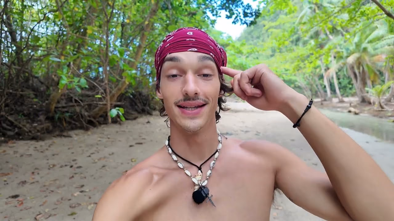 Robert on an empty beach on Dinagat, mangroves and pale sand behind him.
