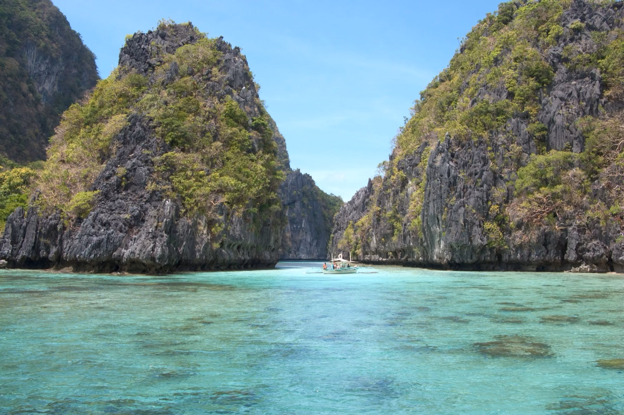 A lagoon ringed by limestone cliffs in Bacuit Bay, El Nido