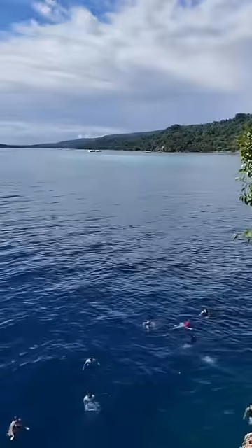 The sea off Samal Island seen from a cliff edge, with the coast of the mainland on the horizon.